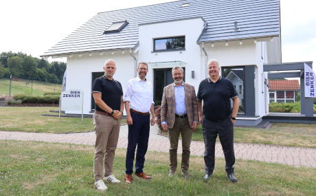 Unser Bild zeigt (von links) Marco D’Agostino (COO), Landrat Thorsten Stolz, Christian Garke (CFO) und Marco Hammer (CEO) vor einem der Bien-Zenker-Musterhäuser am Standort Schlüchtern.