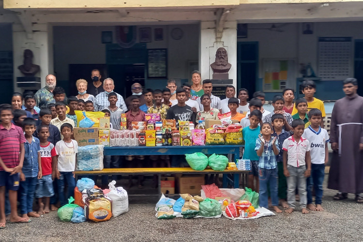 Das Bild zeigt die Übergabe einer Lebensmittelspende an das Waisenhaus Don Bosco.